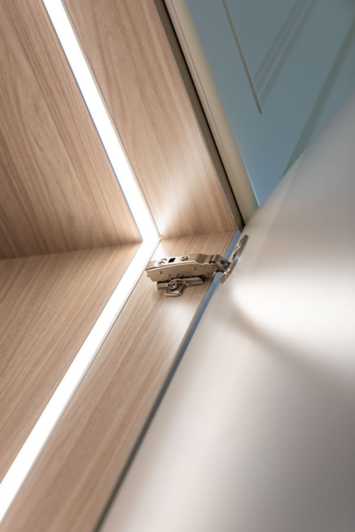 Closeup of high quality hinge and strip lighting on Oxford built-in hinged door wardrobe