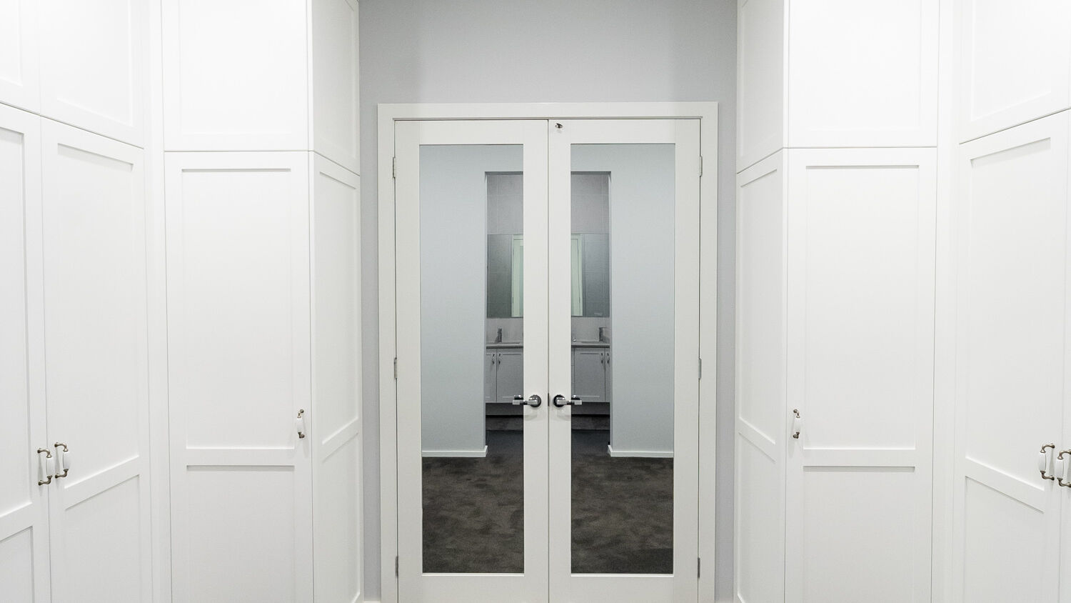 Symmetrical Boston wardrobe layout in Dulux Vivid White 2-pack satin finish, featuring custom-designed dressing room storage by Packers.