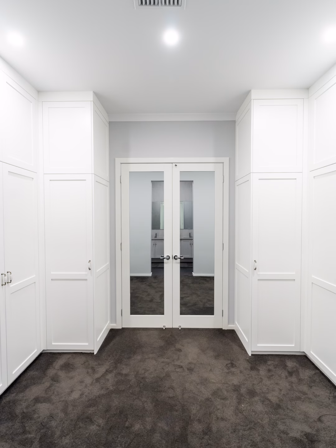 Symmetrical Boston wardrobe layout in Dulux Vivid White 2-pack satin finish, featuring custom-designed dressing room storage by Packers.