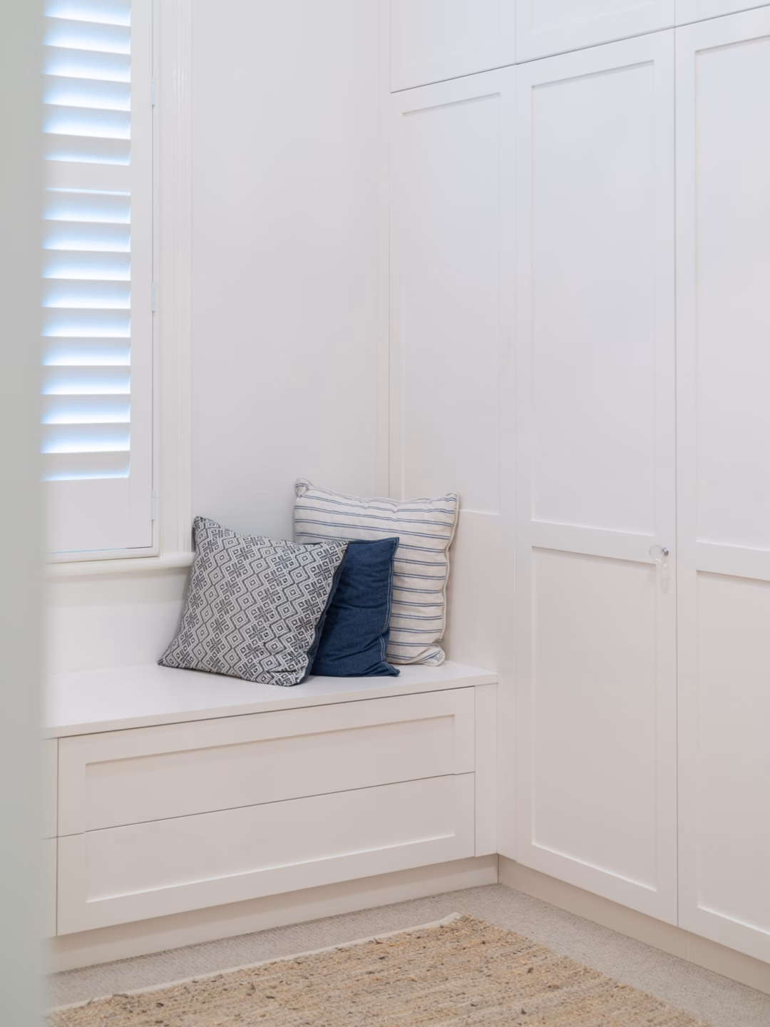 Custom dressing room window seat featuring push-to-open drawers in Solver Paper White 2-pack satin finish, professionally installed by Packers.
