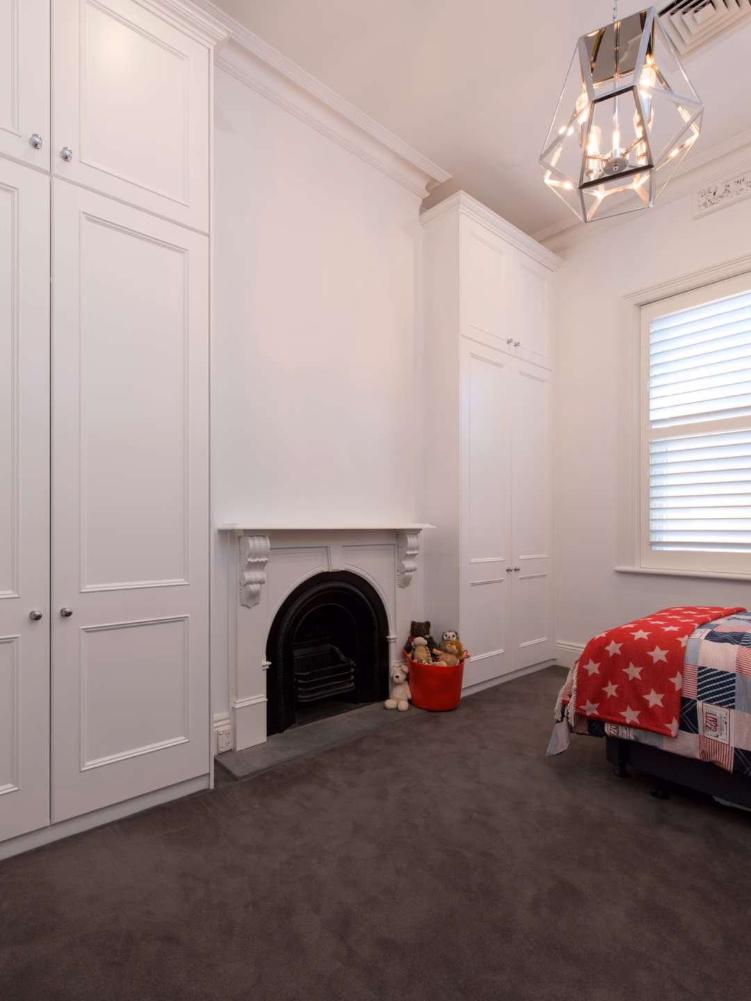 Traditional floor-to-ceiling Oxford wardrobes in Dulux Vivid White 2-pack satin finish, featuring a colonial cornice and custom-built design around a fireplace.