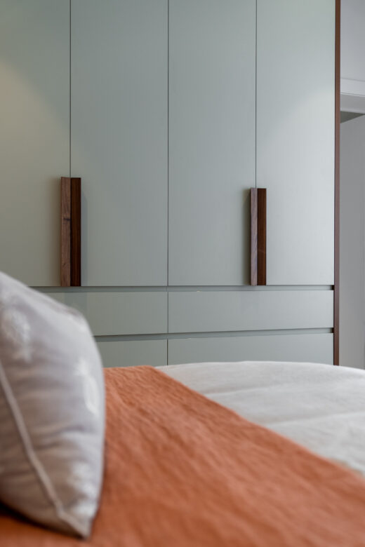 Modern Sorrento flush panel wardrobe featuring a two-tone design in Laminex Seed and Polytec Florentine Walnut, custom-built for a contemporary bedroom by Packers.