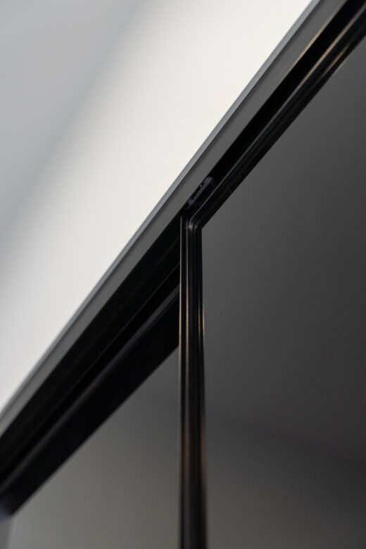 Modern Halifax sliding wardrobe featuring premium black glass panels and slimline black frames, custom-designed for a bold, contemporary aesthetic by Packers.