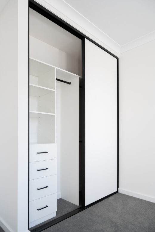 Modern two-door Halifax sliding wardrobe in Polytec Polar White Matt with slimline black frames, featuring an internal classic drawer unit and black hardware by Packers.