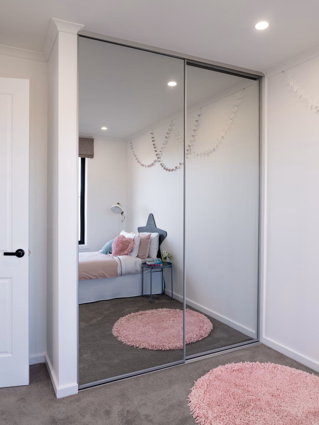 Wall-to-wall Halifax sliding wardrobe featuring two full-length mirrored doors with matt natural frames, custom-fitted for a seamless finish by Packers.