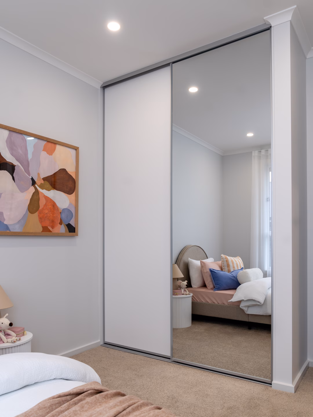 Modern Halifax sliding wardrobe combining white melamine and mirrored panels with matt natural frames, custom-built by Packers.