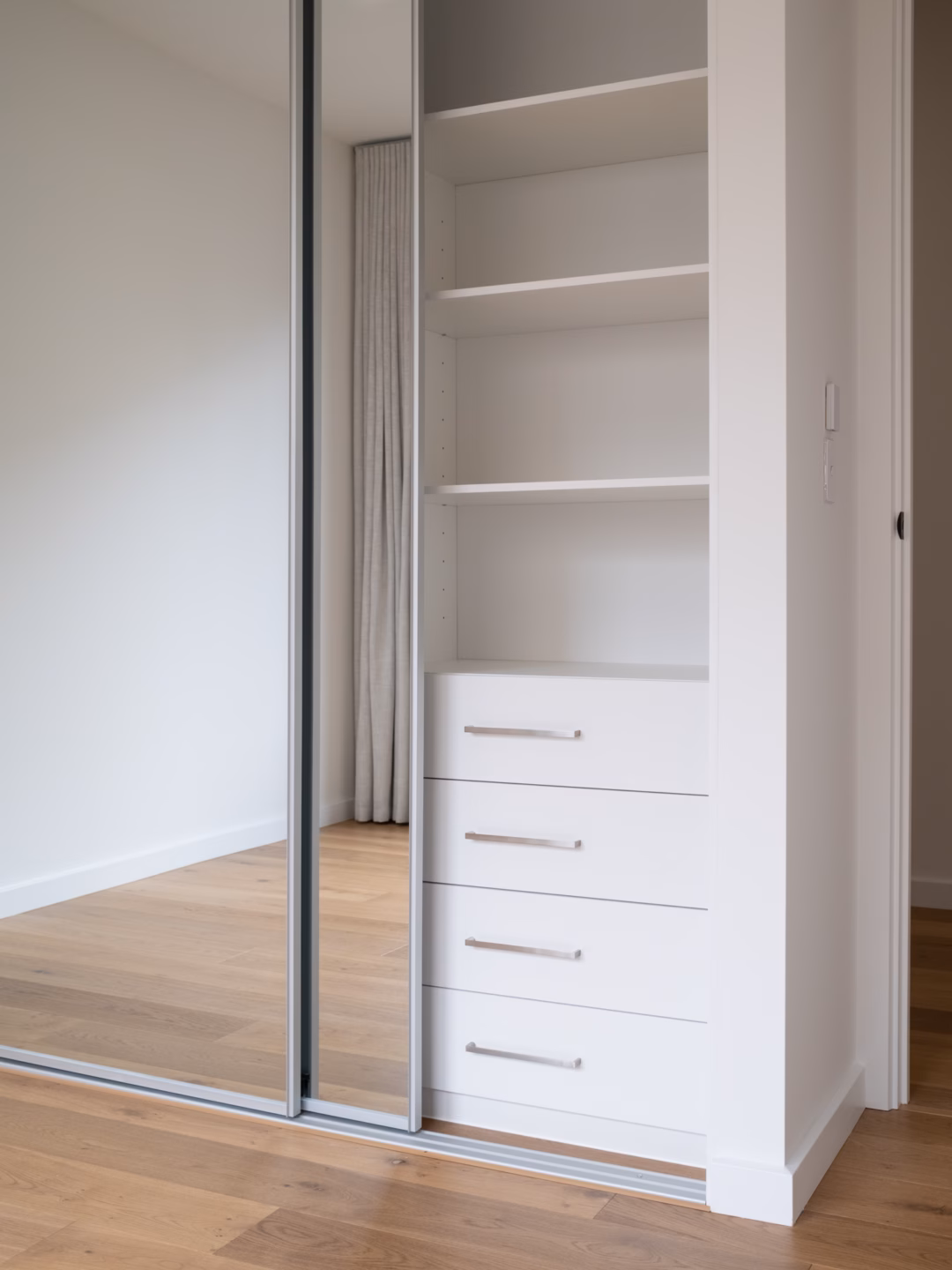 Halifax sliding wardrobe featuring full-length mirror doors with matt natural frames and an internal Alto drawer unit with brushed nickel hardware by Packers.