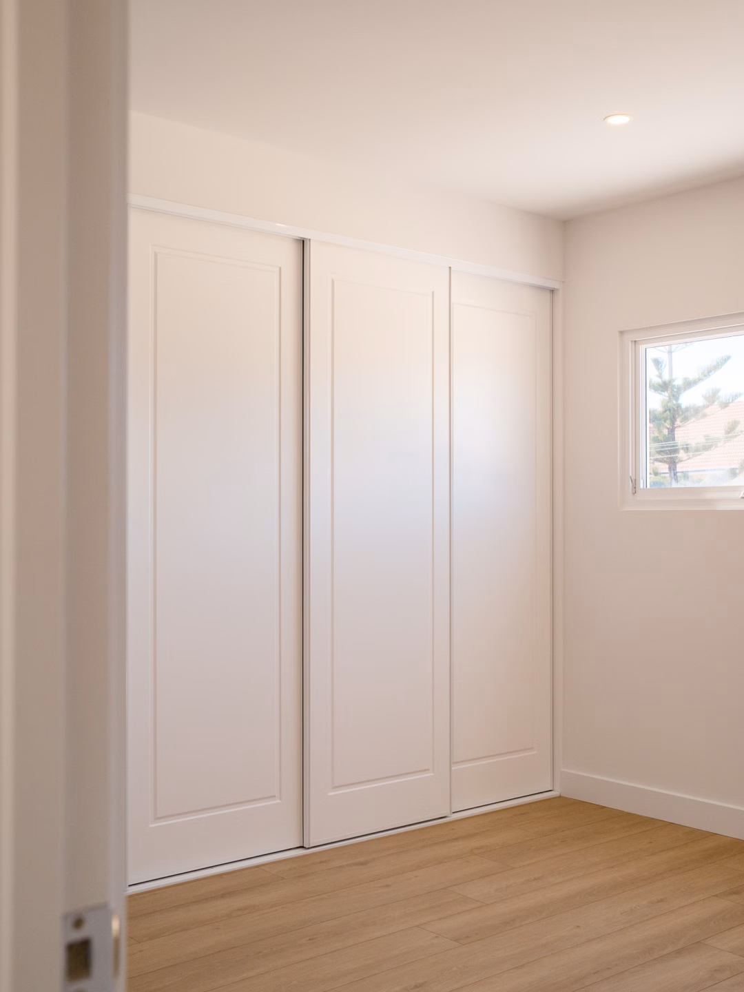 Modern Halifax sliding wardrobe featuring 1-panel routed doors in a Vivid White 2-pack satin finish, custom-built for a seamless bedroom storage solution by Packers.