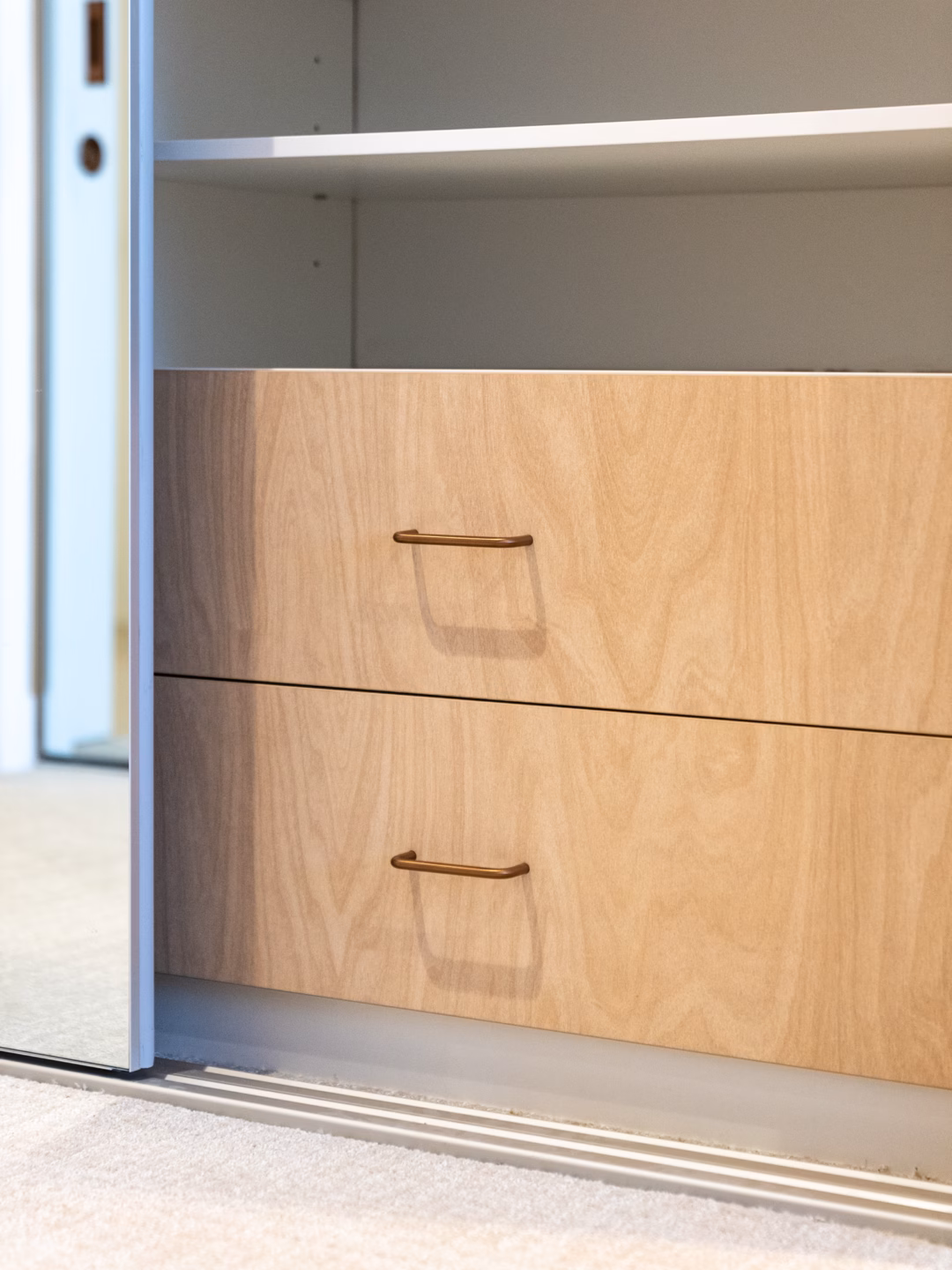 Internals of a Portsea sliding wardrobe featuring custom drawer units with coloured internal drawer fronts for a personalised storage solution by Packers.