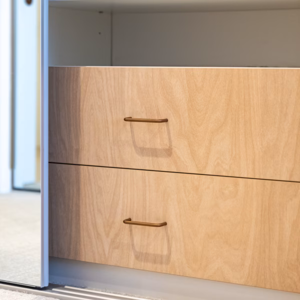 Internals of a Portsea sliding wardrobe featuring custom drawer units with coloured internal drawer fronts for a personalised storage solution by Packers.