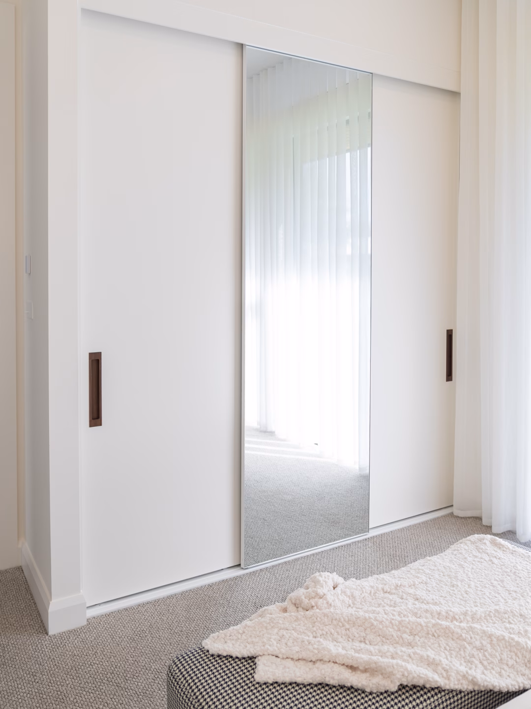 Premium three-door wardrobe featuring two Waterford doors in Dulux Natural White 2 Pack Satin finish and a Portsea mirrored door with a slimline white frame, custom-built by Packers.