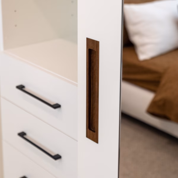 Close-up of a custom wardrobe featuring a handcrafted Spotted Gum recessed timber handle, integrated into a high-end cabinet door by Packers.