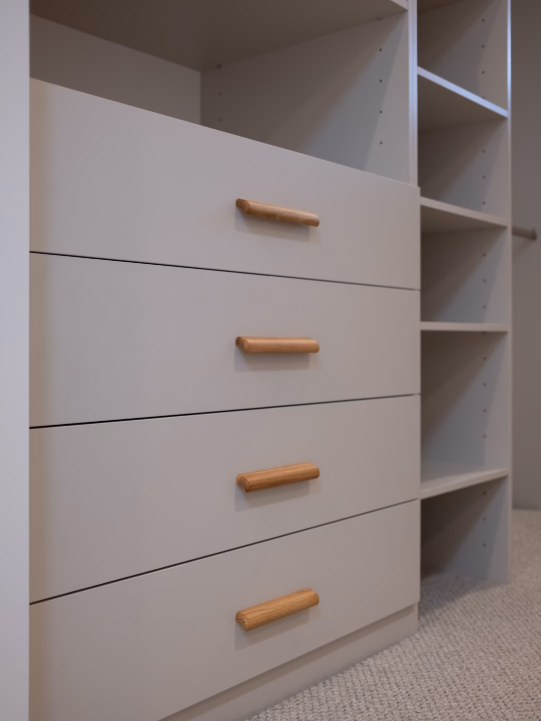 Standard walk-in robe in Polytec Amaro Matt featuring a custom drawer unit with Furnipart Glove Oak handles positioned alongside a matching shoe tower, by Packers.