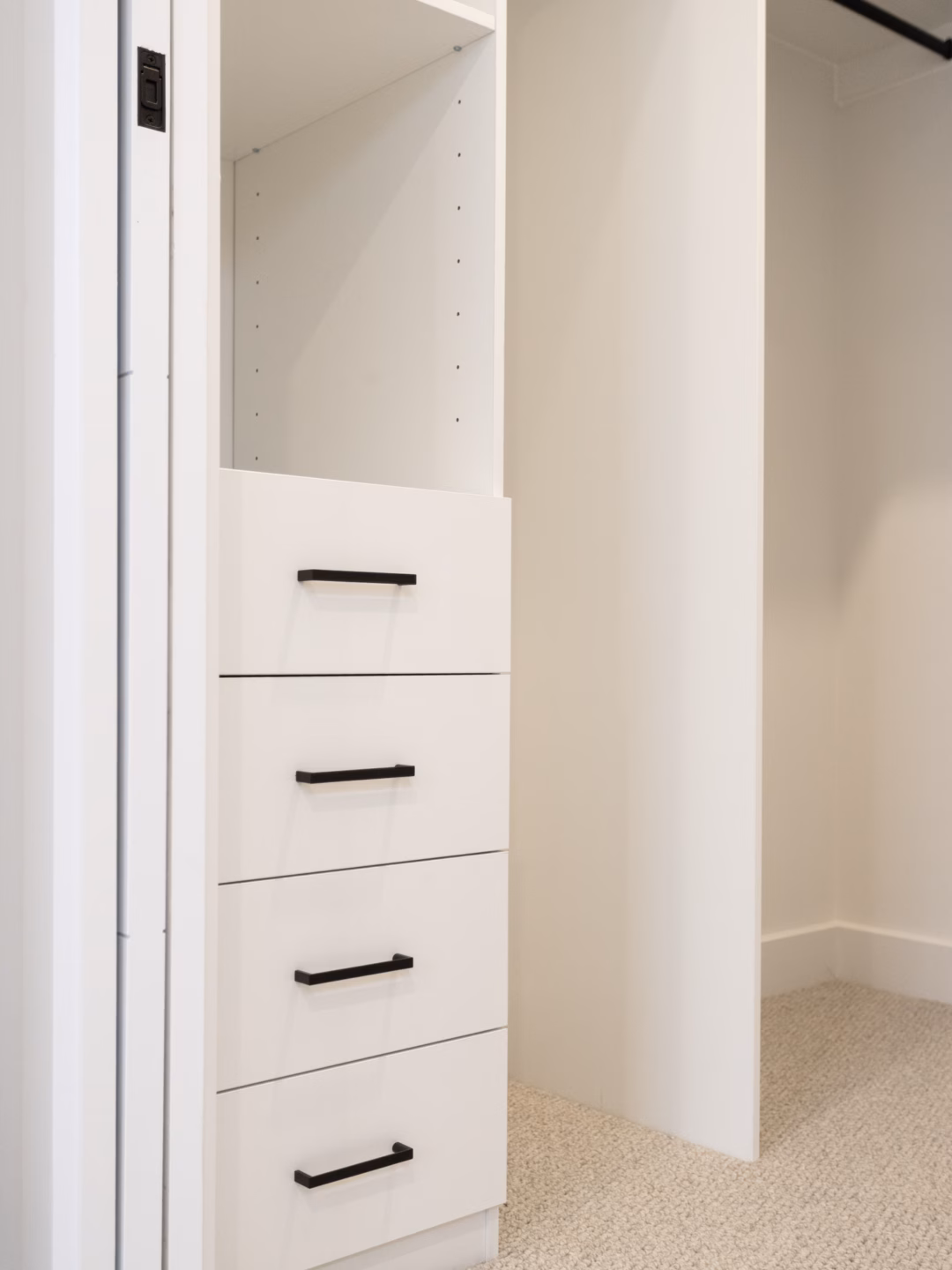 Standard walk-in robe in a clean white carcass finish featuring a classic drawer unit and contrasting matte black hanging rails and hardware, custom-built by Packers.