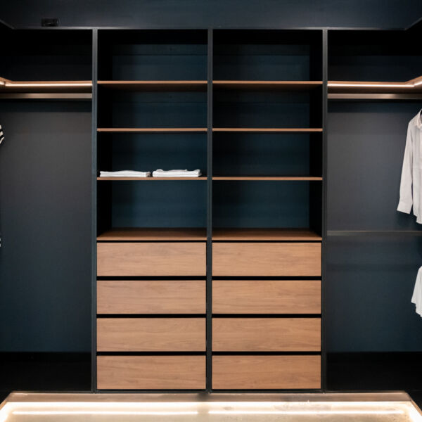 Semi-carcass walk-in robe featuring a sophisticated pairing of Polytec Black Woodmatt and Polytec Florentine Walnut Woodmatt for a high-end, architectural finish by Packers.