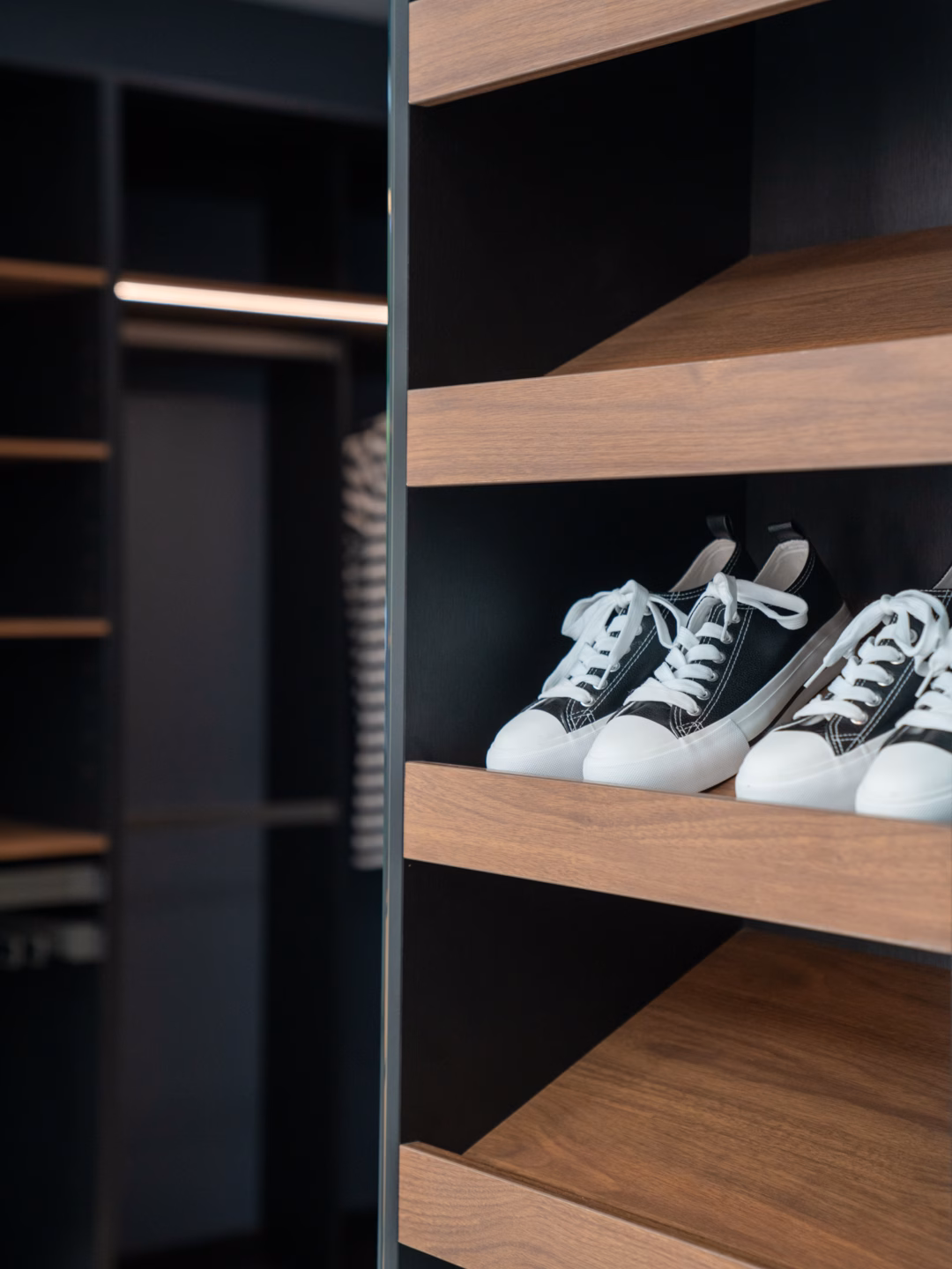 Close-up of custom angled shoe shelves in Polytec Florentine Walnut Woodmatt, showcasing a premium textured timber finish and organised footwear display by Packers.