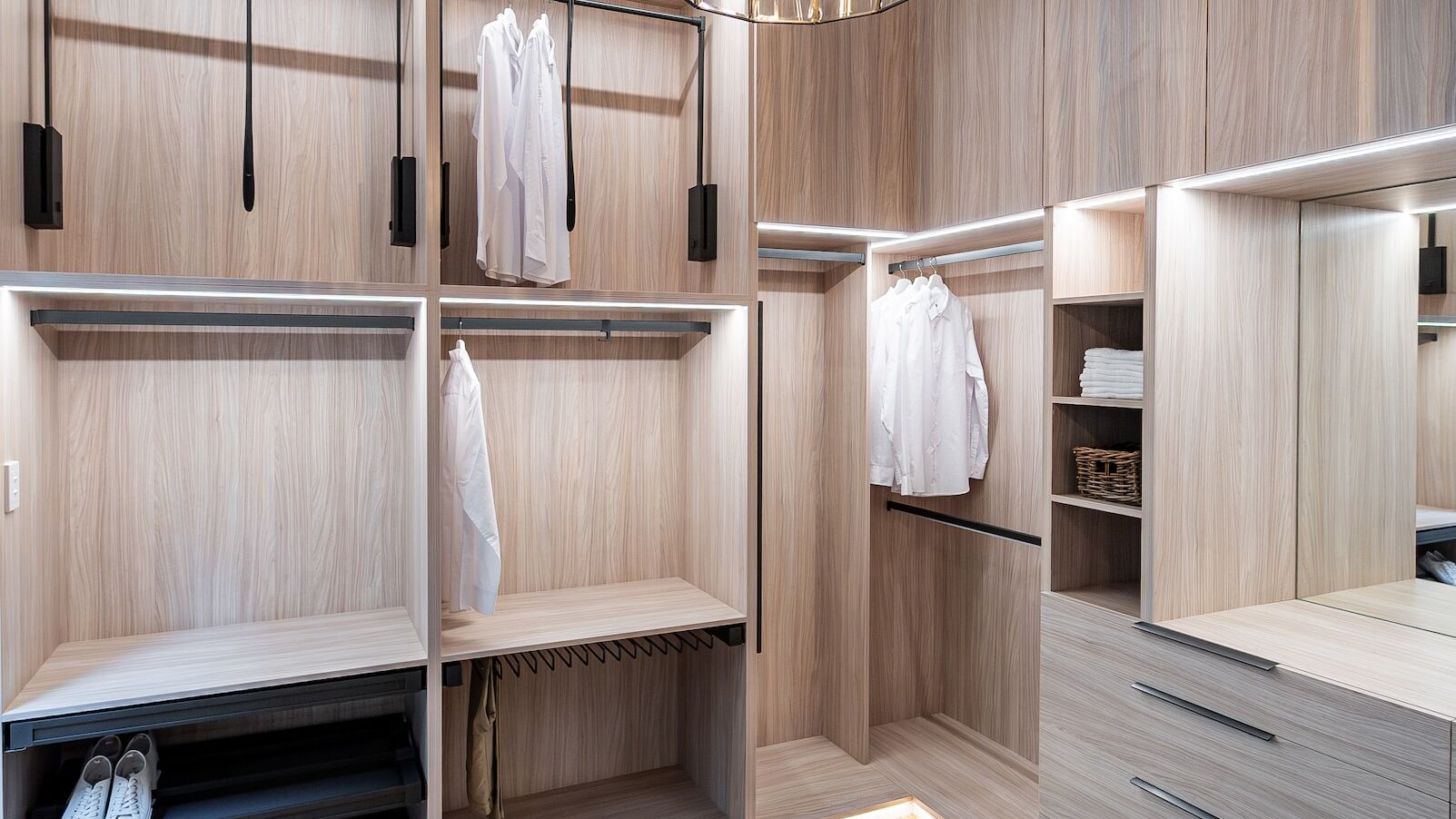 Luxury full carcass walk-in robe showroom display in Polytec Soft Walnut Ravine featuring Häfele Conero accessories, integrated LED lighting, and premium hinged overhead units, custom-built by Packers.