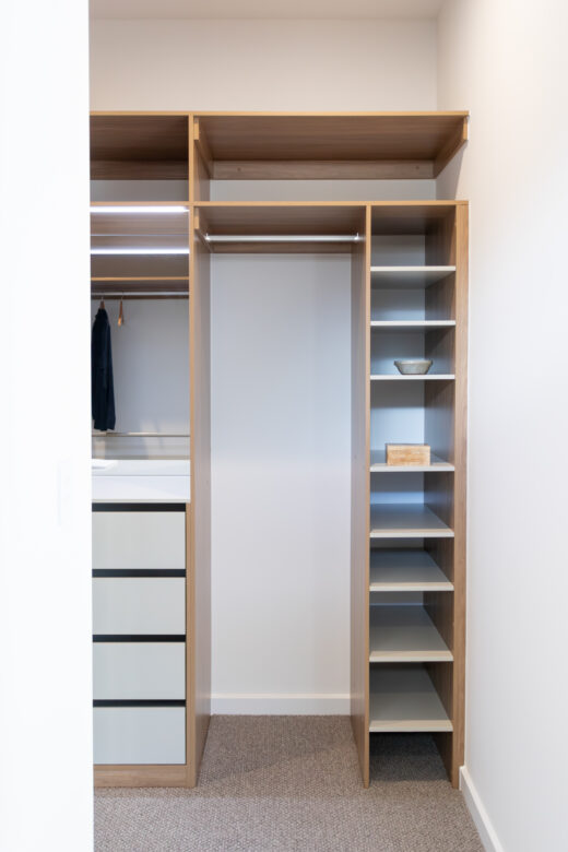 Custom-built walk-in robe featuring Polytec Prime Oak and Verdelho Smooth internals, including an adjustable shoe shelf tower and long hanging section at 2100mm high, by Packers.