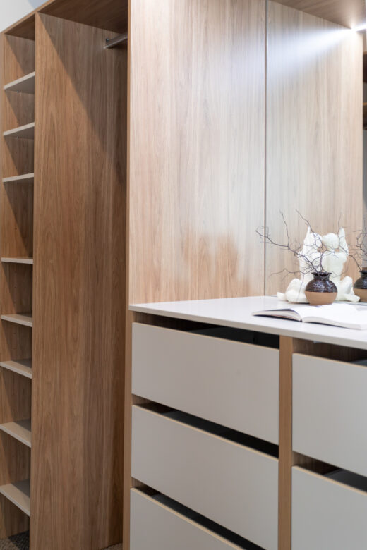 Bespoke walk-in robe featuring an integrated mirror dresser unit and slim-walled Alto inset drawers, custom-built by Packers.