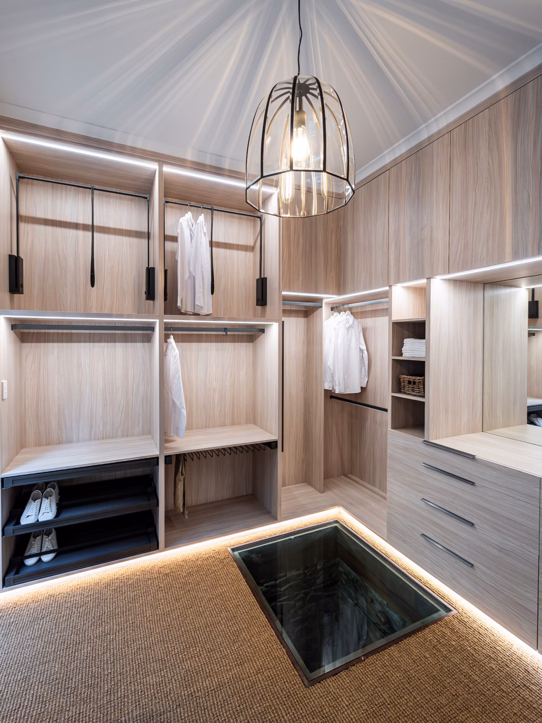 Luxury full carcass walk-in robe showroom display in Polytec Soft Walnut Ravine featuring Häfele Conero accessories, integrated LED lighting, and premium hinged overhead units, custom-built by Packers.