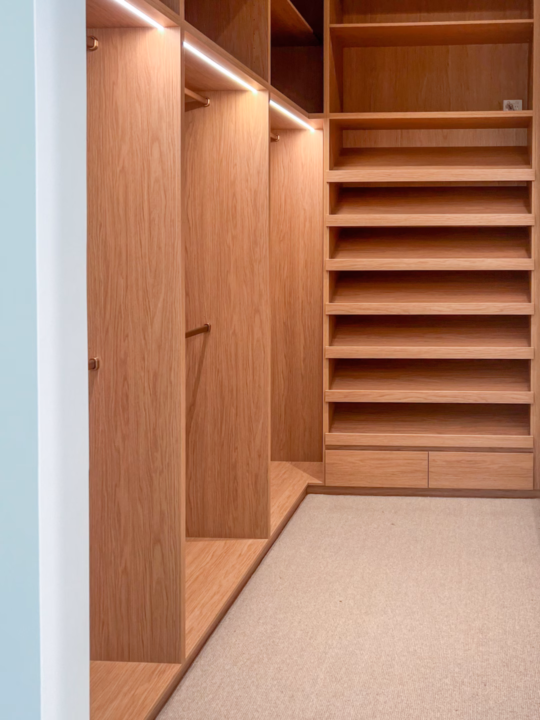 Luxury full carcass walk-in robe in Polytec Boston Oak Woodmatt featuring integrated LED strip lighting and a seamless fully lined interior, custom-built by Packers.