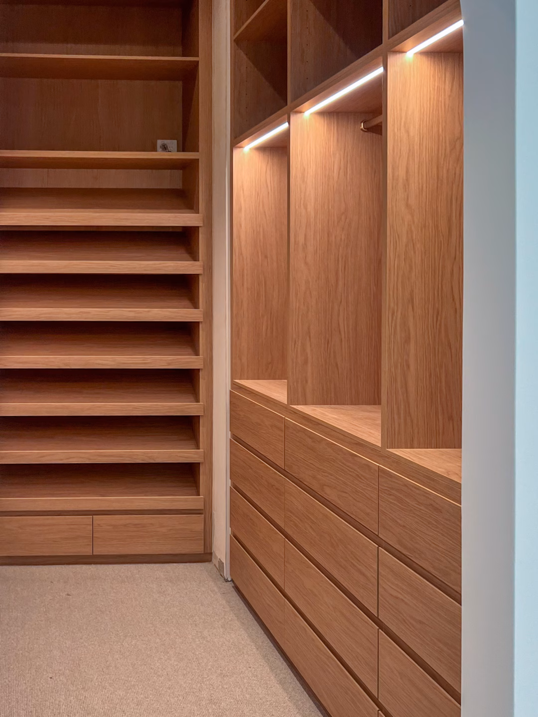 Luxury full carcass walk-in robe in Polytec Boston Oak Woodmatt featuring integrated LED strip lighting and a seamless fully lined interior, custom-built by Packers.