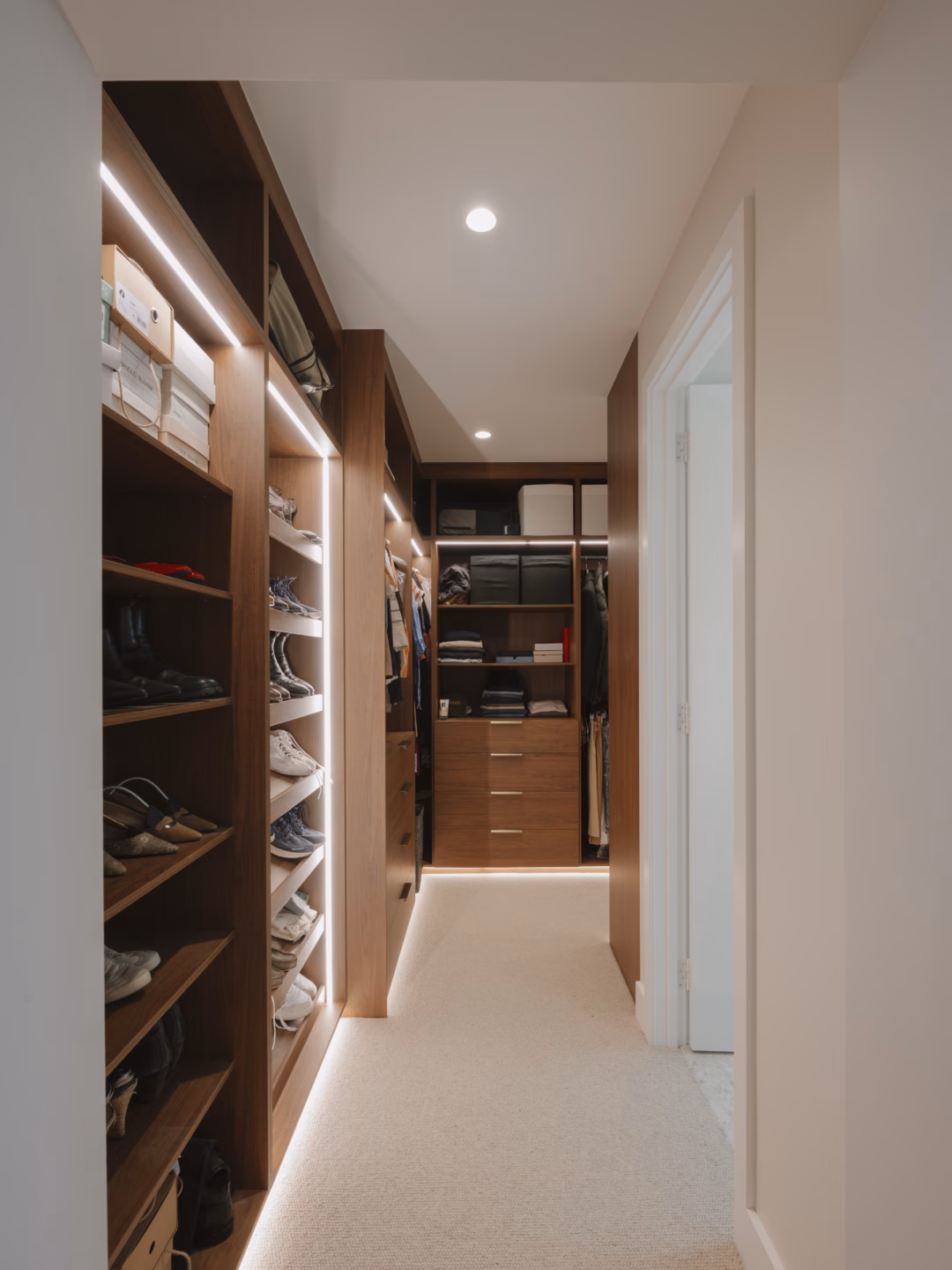 Bespoke full carcass walk-in robe in Polytec Florentine Walnut featuring Lo & Co Lincoln 200mm pulls in aged brass, custom-crafted by Packers.