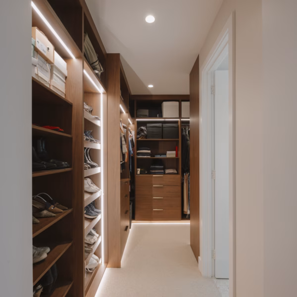 Bespoke full carcass walk-in robe in Polytec Florentine Walnut featuring Lo & Co Lincoln 200mm pulls in aged brass, custom-crafted by Packers.